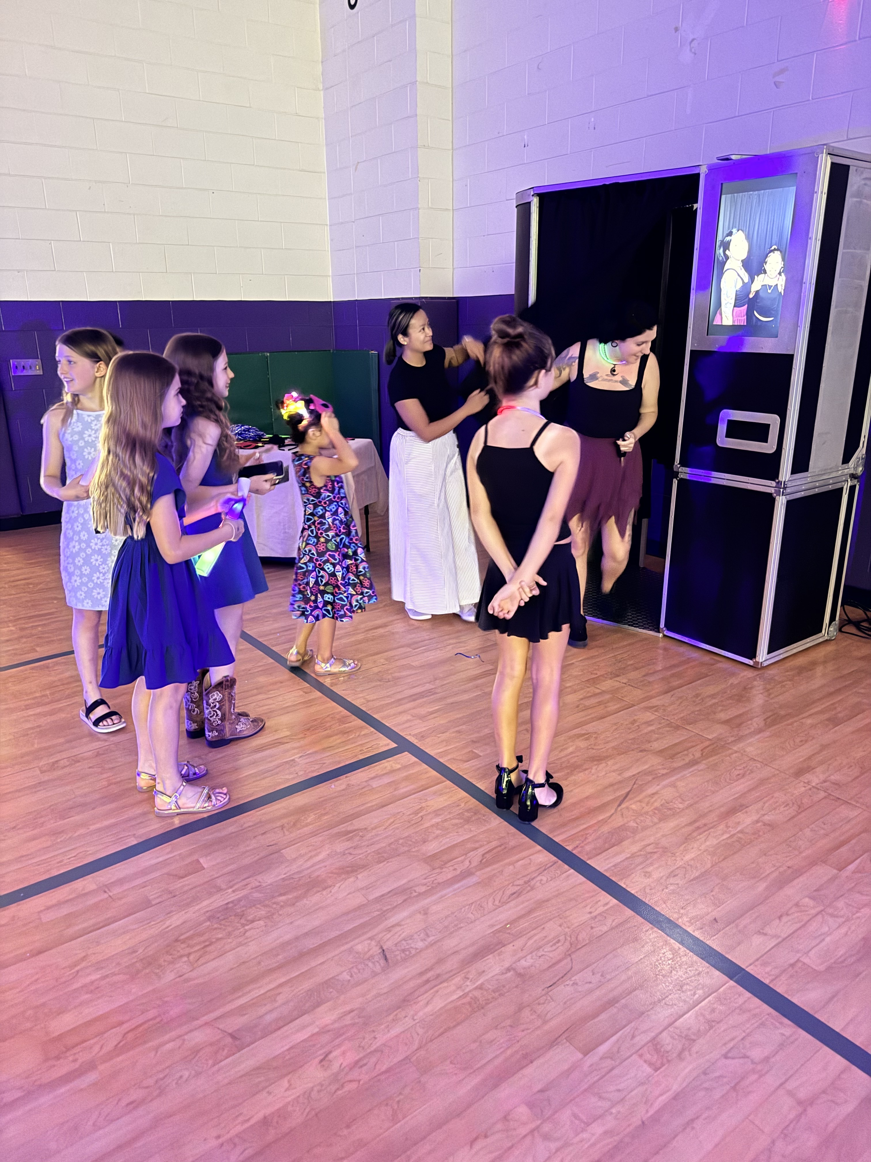 A photo booth attendant helping students take photos at an end-of-year school celebration